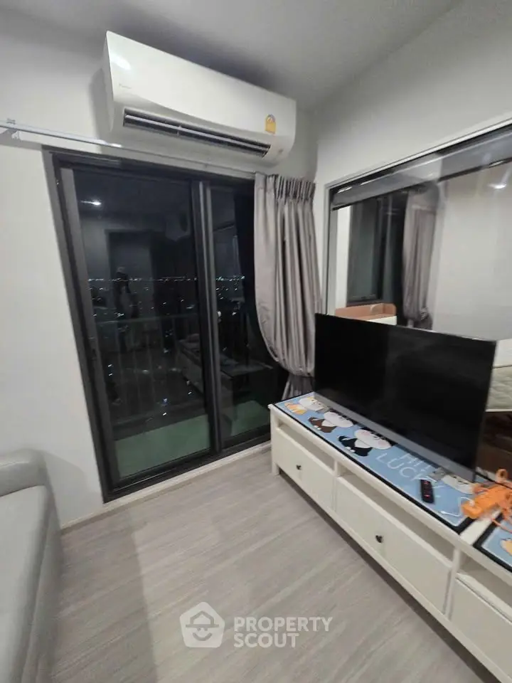 Modern living room with balcony access and sleek air conditioning unit.