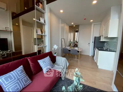 Modern open-plan living room with stylish kitchen and dining area, featuring elegant decor and cozy seating.