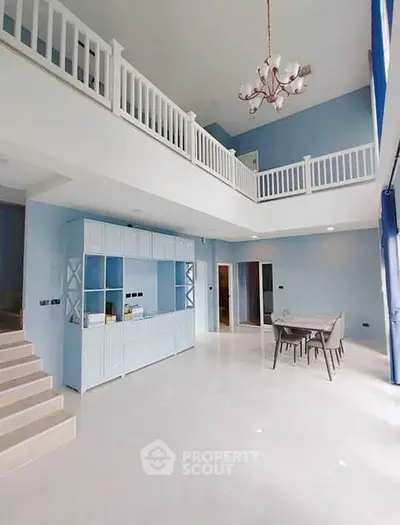 Spacious two-story living room with elegant chandelier and modern dining area.