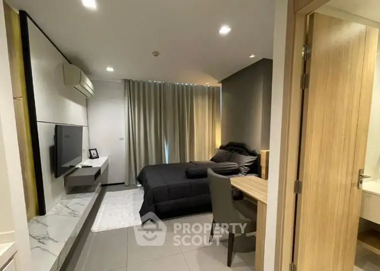 Modern bedroom with sleek design, featuring a cozy bed, wall-mounted TV, and stylish decor.