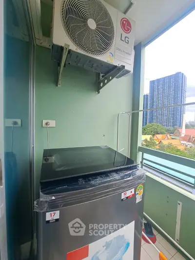 Modern balcony with washing machine and air conditioning unit, offering cityscape views.