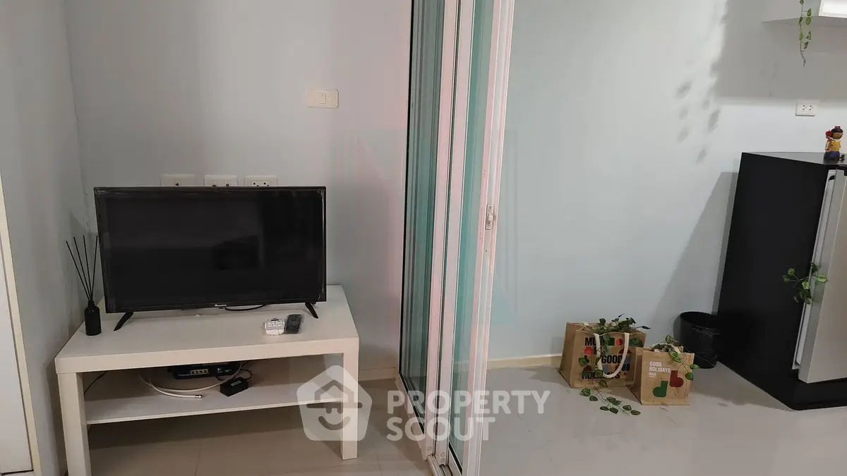 Modern living room with TV and sliding glass door, minimalistic decor