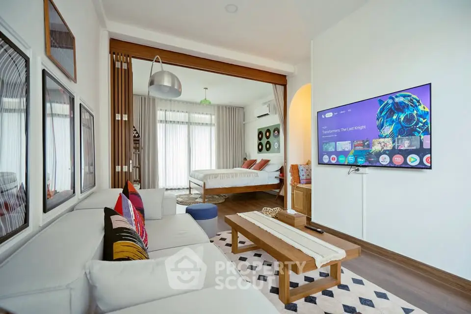 Modern open-concept living room with stylish decor and wall-mounted TV