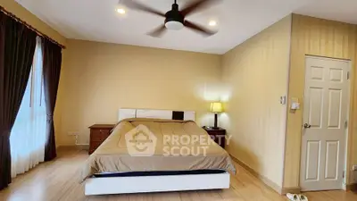 Spacious bedroom with modern decor and ceiling fan in a cozy home.