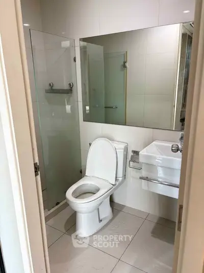 Modern bathroom with glass shower and sleek fixtures in a contemporary home.