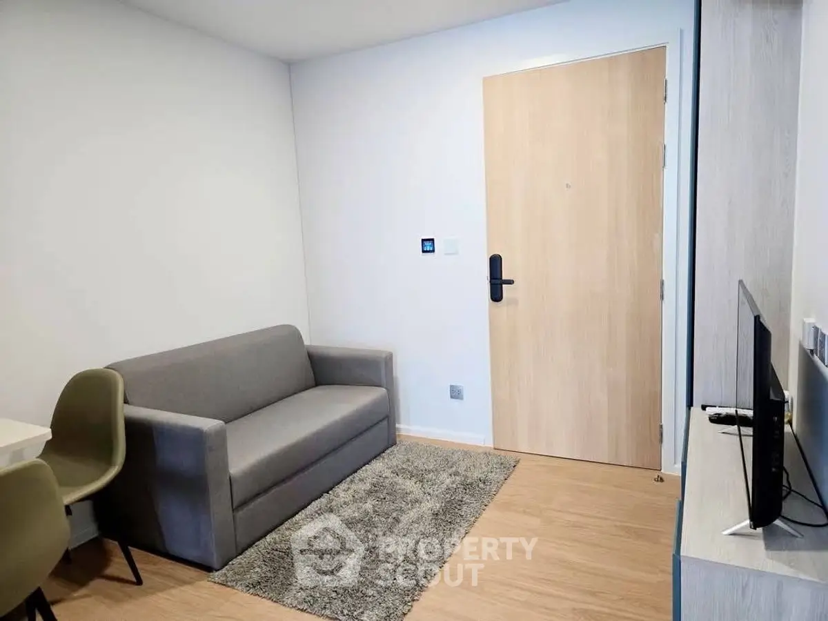 Modern compact living room with cozy sofa and TV setup, perfect for urban living.