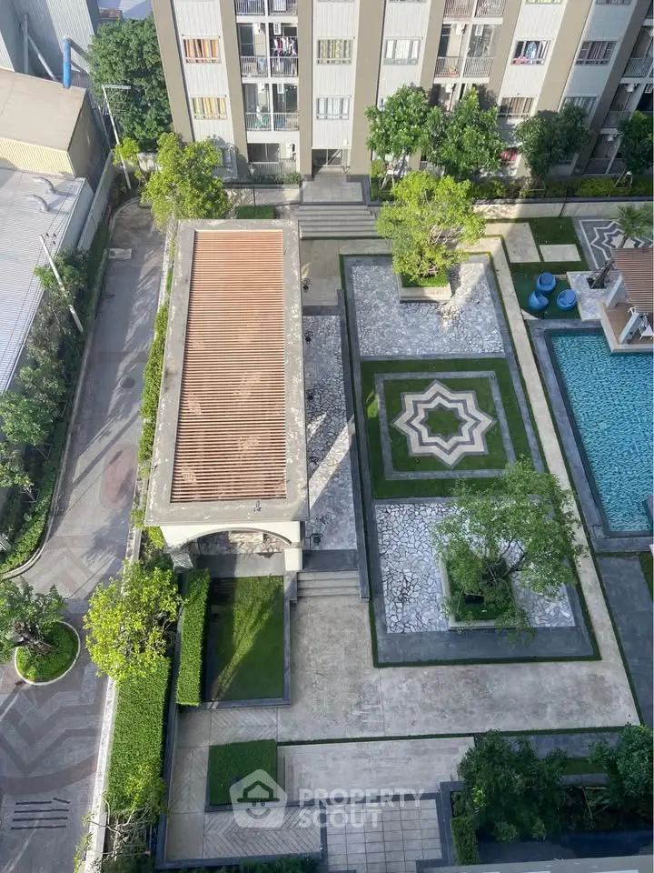 Aerial view of modern residential complex with pool and landscaped garden.