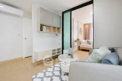 Modern living room with stylish decor and open layout leading to bedroom.