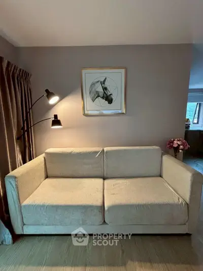 Cozy living room with modern beige sofa and stylish wall art, perfect for relaxation.