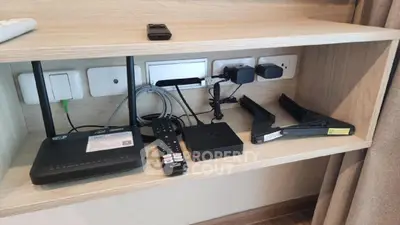 Modern living room with built-in entertainment shelf and electronic devices