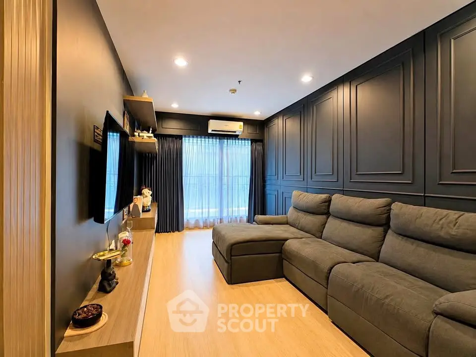 Modern living room with sleek design, featuring a comfortable sectional sofa and ambient lighting.