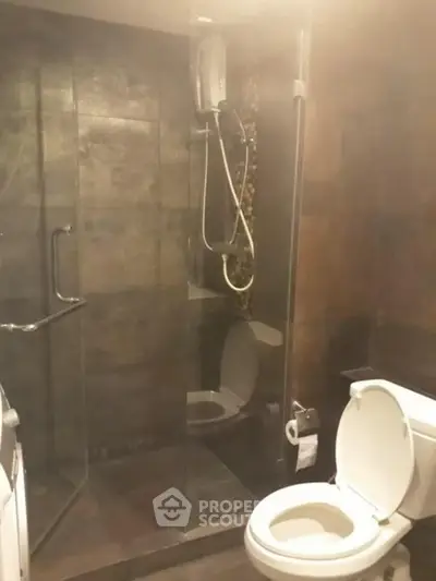 Modern bathroom with glass shower and toilet in contemporary apartment.