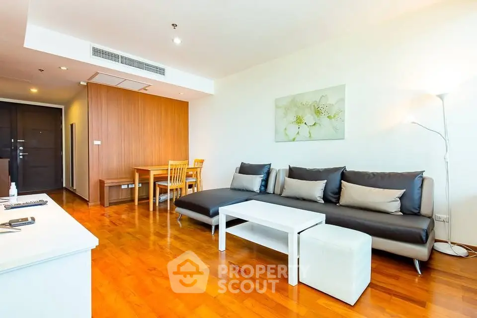 Spacious modern living room with wooden flooring and stylish furniture in a contemporary apartment.