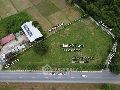 Aerial view of a large plot of land with dimensions and surrounding greenery.