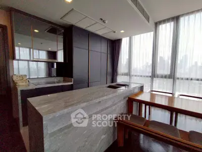 Modern kitchen with sleek design and open layout, featuring a stylish island and dining area with city views.