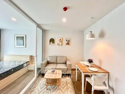 Modern living room with cozy sofa, dining area, and stylish decor in open-plan apartment.