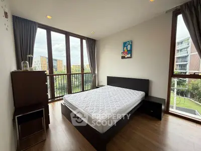 Spacious bedroom with large windows and scenic view in modern apartment