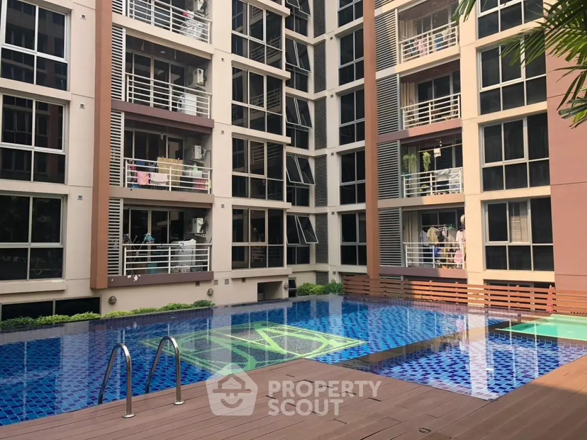 Modern apartment complex with inviting swimming pool and stylish architecture.