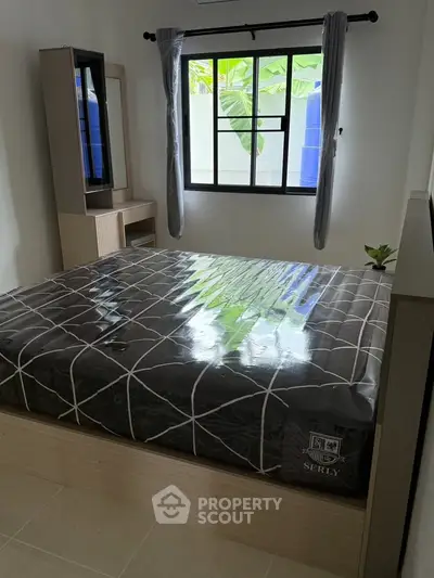 Modern bedroom with large window and stylish bed, perfect for comfort and relaxation.