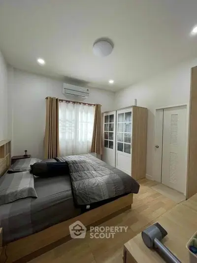 Cozy bedroom with modern decor and ample natural light