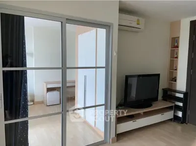 Modern living room with sliding glass doors and sleek entertainment unit.