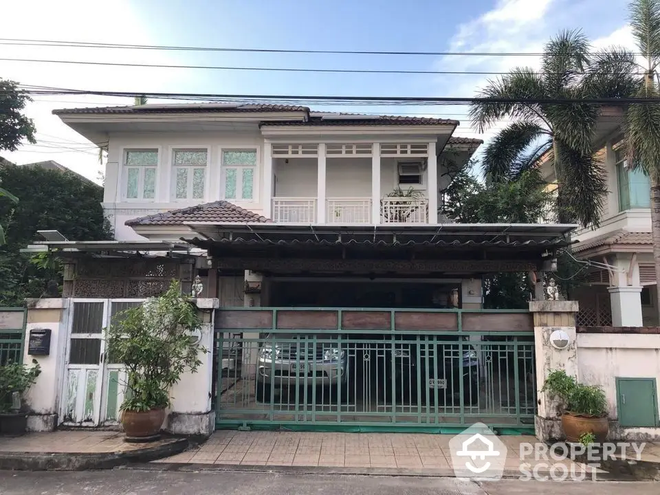 Charming two-story residence with traditional design, featuring a spacious balcony and gated entrance, nestled in a serene neighborhood.