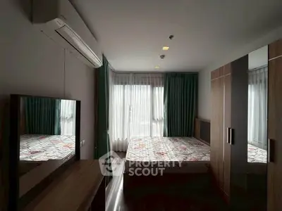 Modern bedroom with large window, stylish wardrobe, and air conditioning unit.