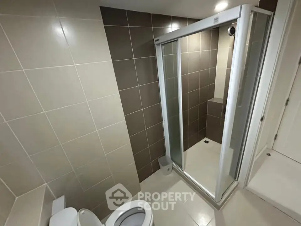 Modern bathroom with sleek shower enclosure and neutral tile design