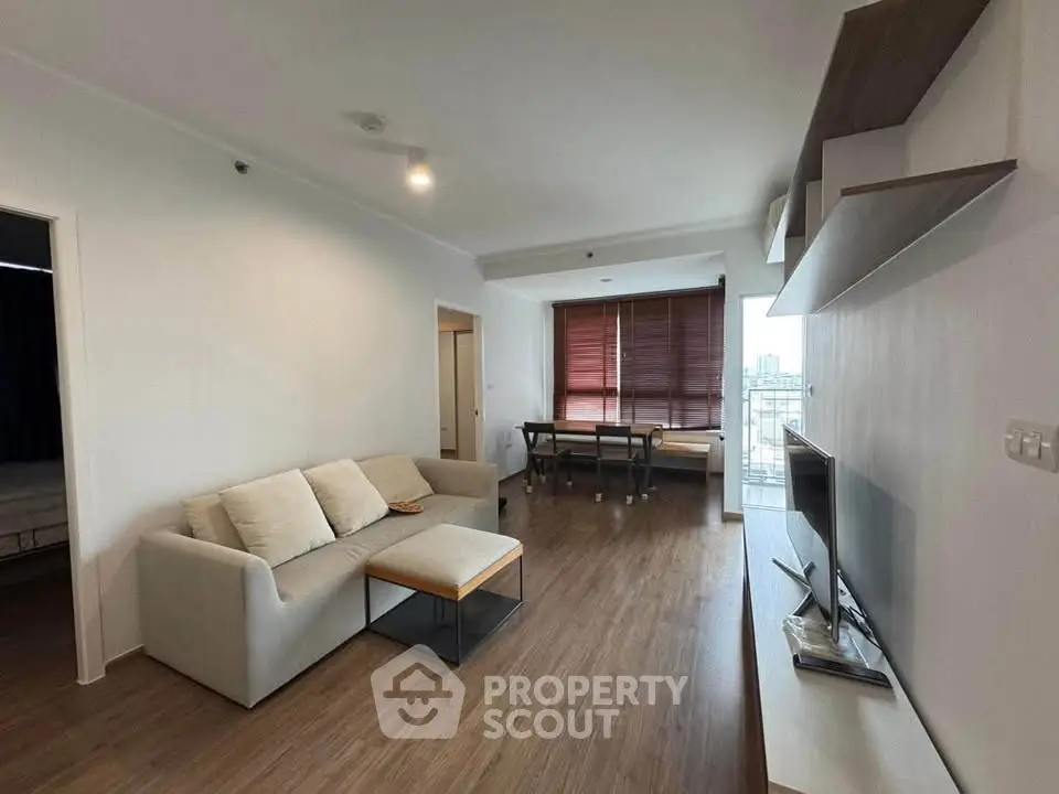 Modern living room with sleek furniture and large windows offering natural light.