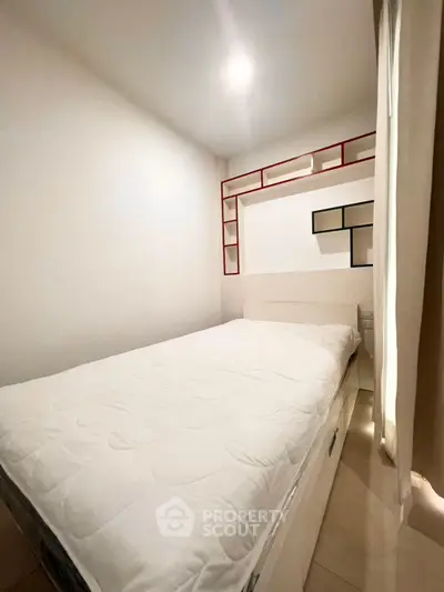 Cozy bedroom with modern shelving and natural light, perfect for relaxation and comfort.