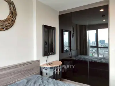 Modern bedroom with mirrored wardrobe and city view from window