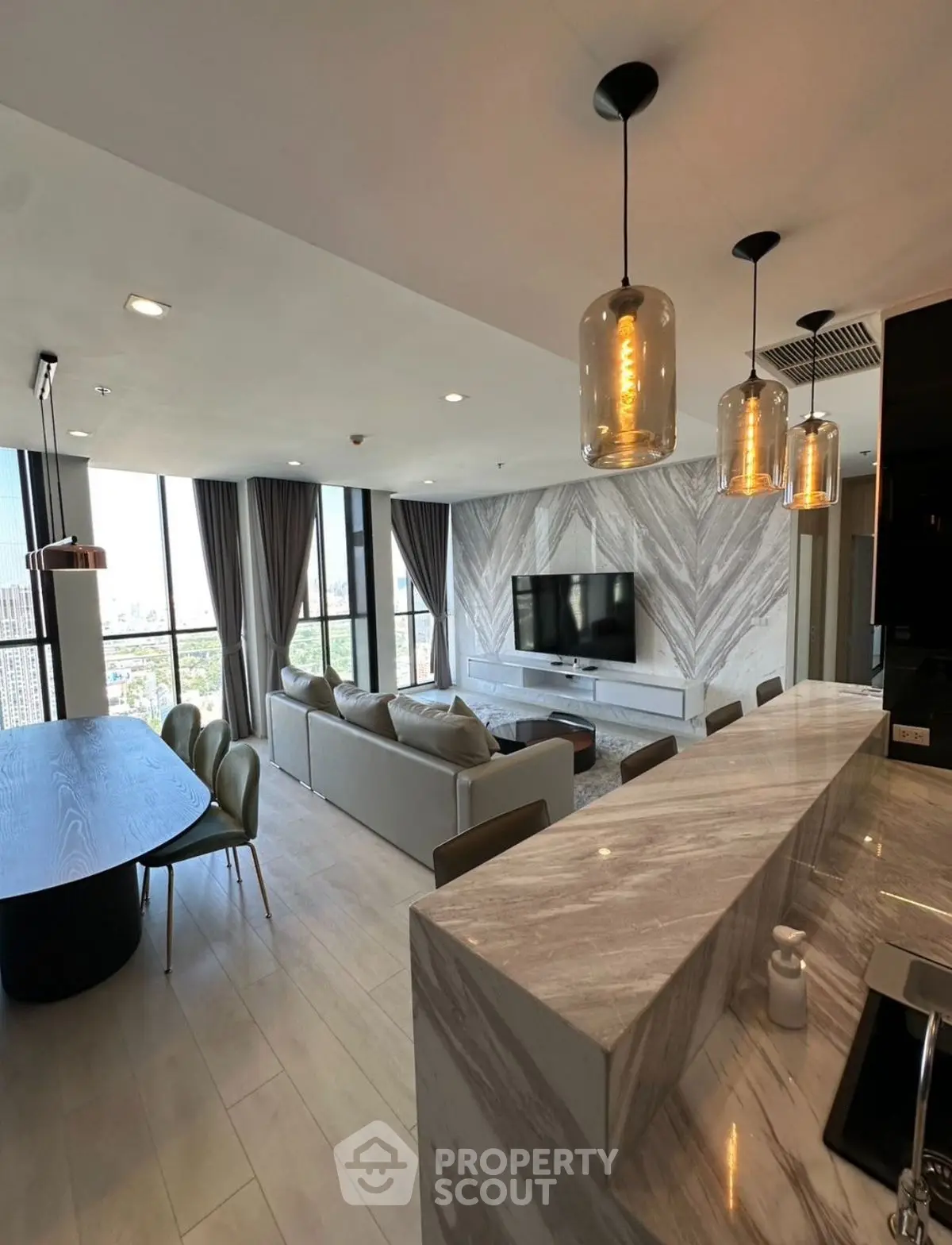 Luxurious open-plan living room with modern kitchen and stunning city view.