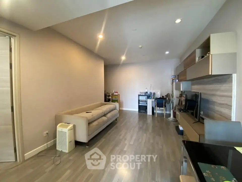 Spacious modern living room with sleek flooring and stylish furniture, perfect for comfortable living.