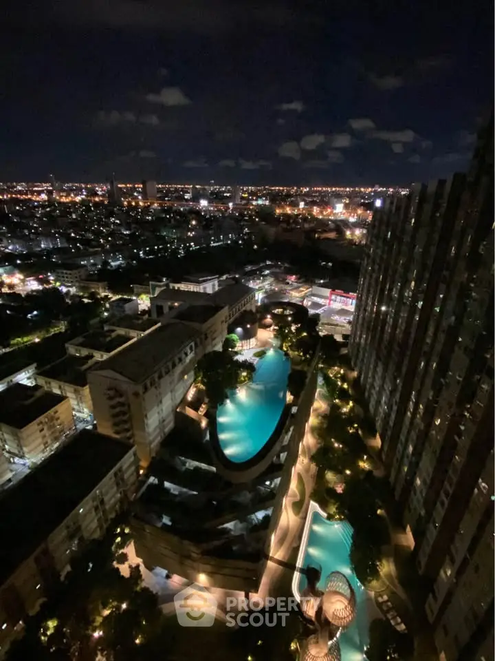 Stunning night view of a cityscape with illuminated swimming pools and high-rise buildings.
