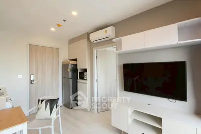 Modern living room with sleek furniture and built-in storage, featuring a wall-mounted TV and air conditioning.