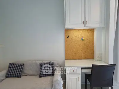 Cozy study nook with built-in desk and comfortable seating in modern apartment.