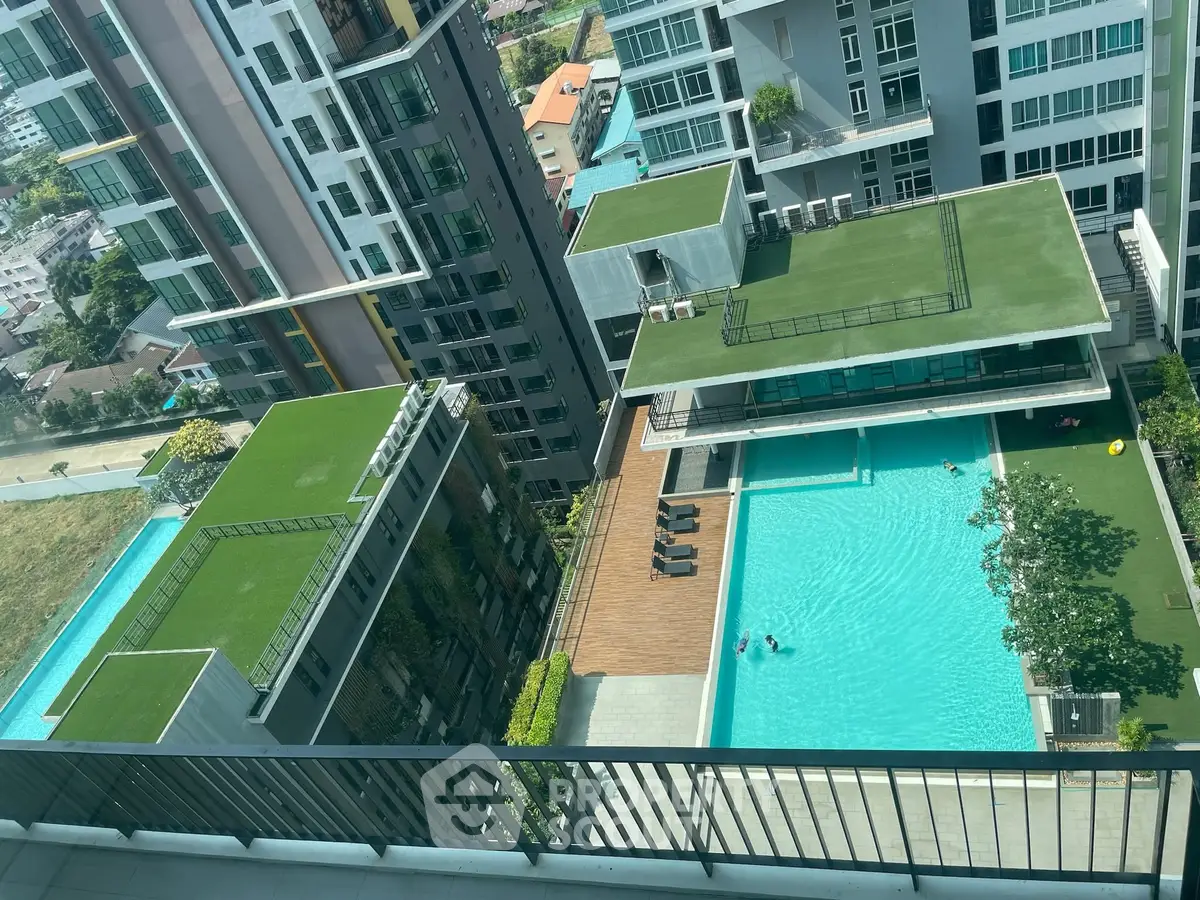 Stunning aerial view of modern apartment complex with rooftop gardens and inviting swimming pool.