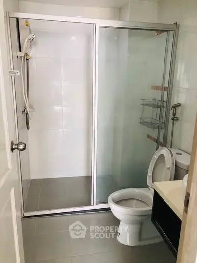 Modern bathroom with glass shower enclosure and sleek fixtures.