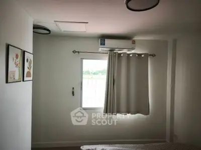 Cozy bedroom with air conditioning and natural light from window, perfect for relaxation.