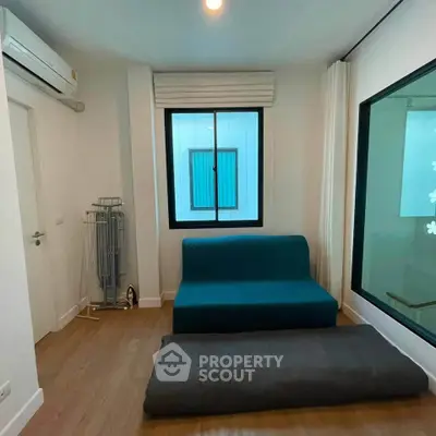 Cozy modern living room with blue sofa and large window