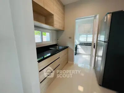 Modern kitchen with sleek cabinets and large fridge in a bright home