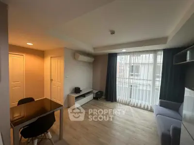 Modern living room with sleek furniture and large window for natural light.