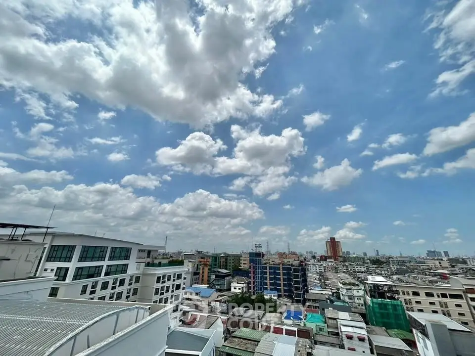 Stunning cityscape view from a high-rise building showcasing urban skyline under a vibrant blue sky.