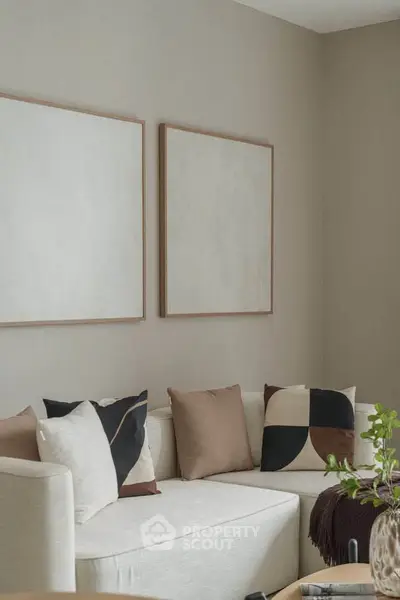 Stylish modern living room with neutral tones and abstract art, perfect for relaxation and entertaining.