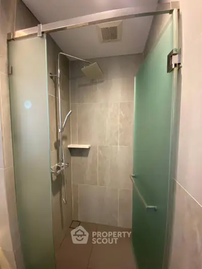Modern bathroom with frosted glass shower doors and sleek fixtures
