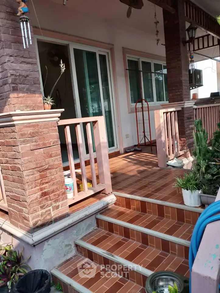 Charming home entrance with brick accents and cozy porch, perfect for relaxing outdoors.