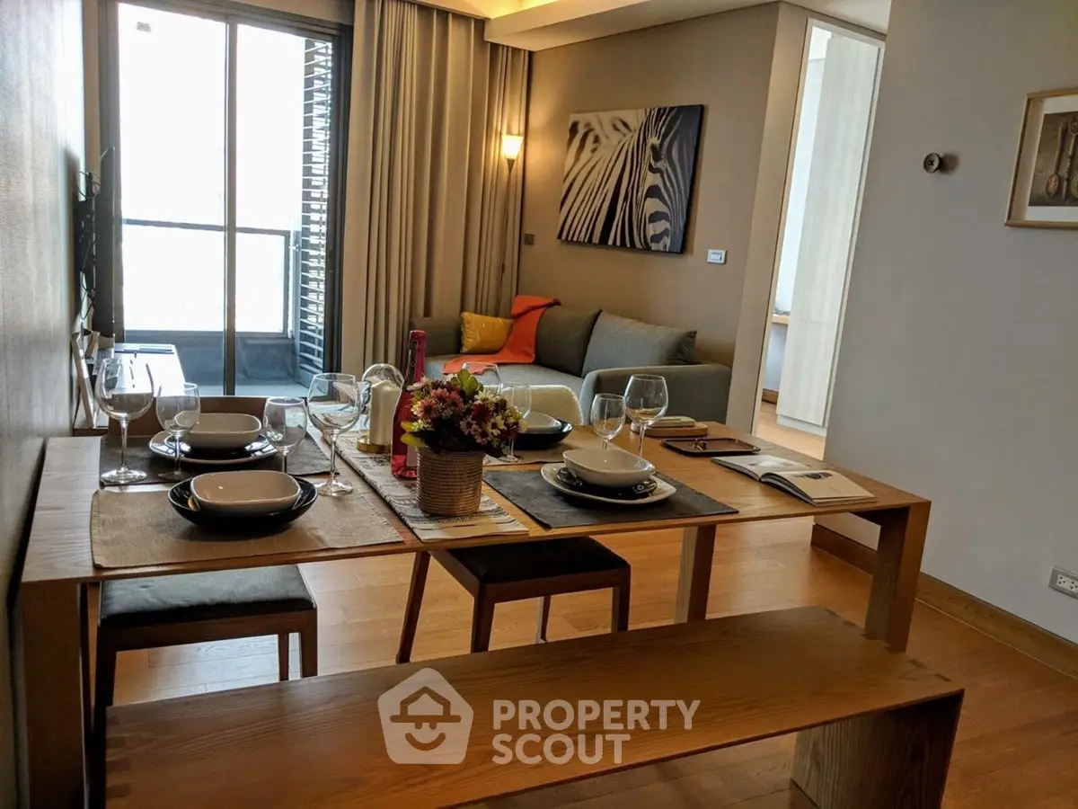 Stylish dining area with wooden table and cozy living room in modern apartment