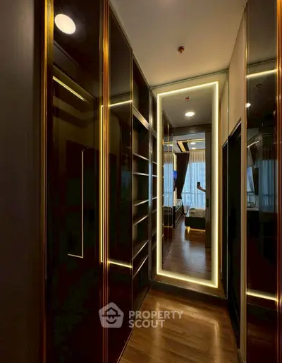 Luxurious walk-in closet with elegant lighting and mirrored accents