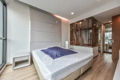 Modern bedroom with large windows and sleek design in a contemporary apartment.