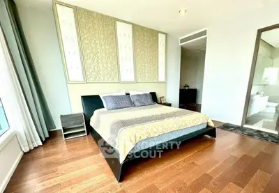 Spacious bedroom with elegant decor and hardwood flooring